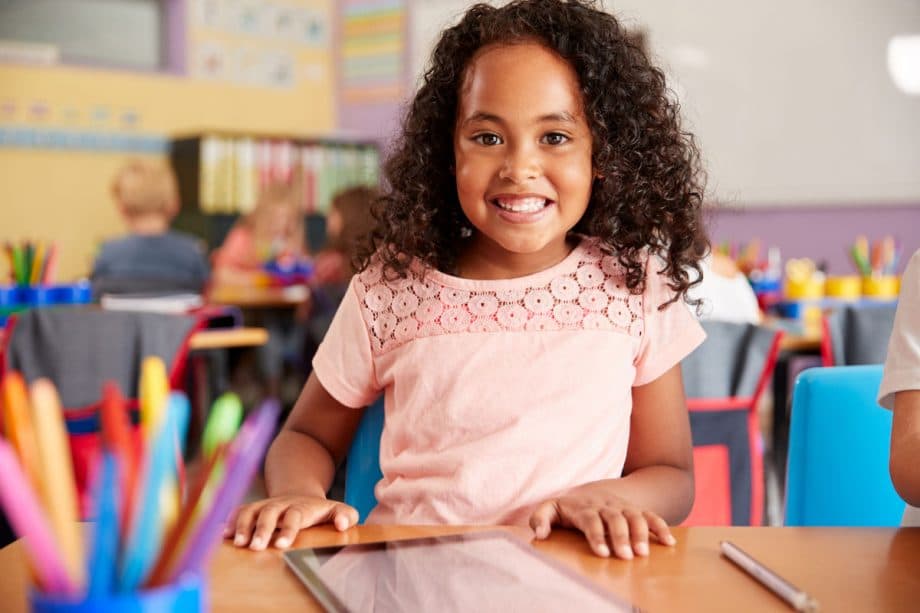 curly haired girl smiling in classroom