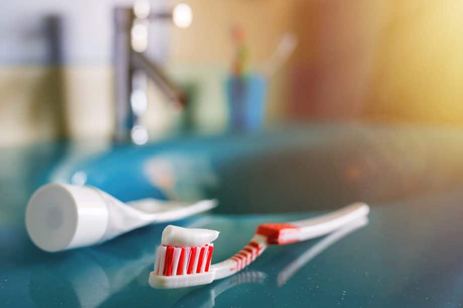 red and white toothbrush with toothpaste